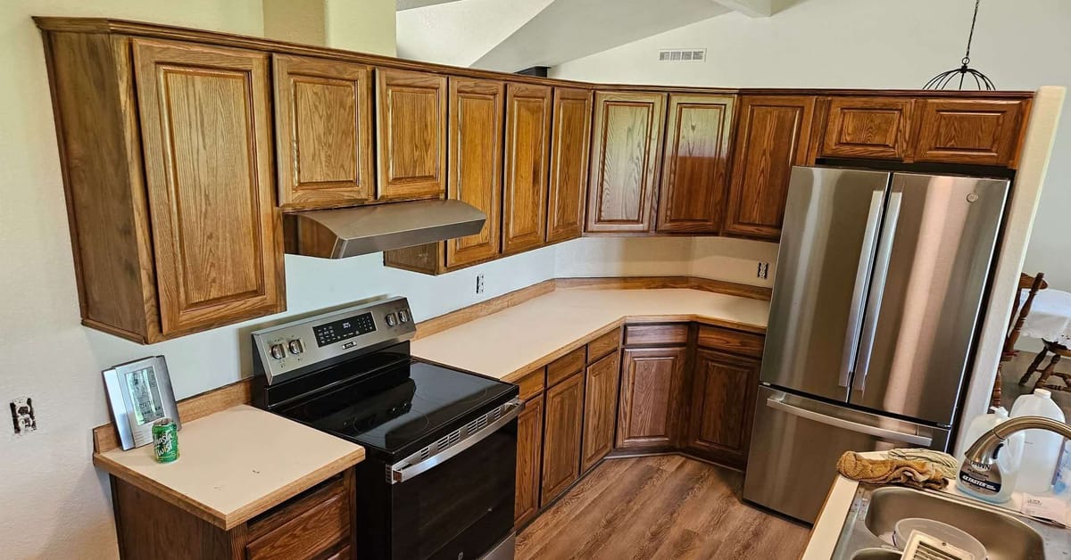 Refinished oak kitchen cabinets with a warm stain and new stainless appliances