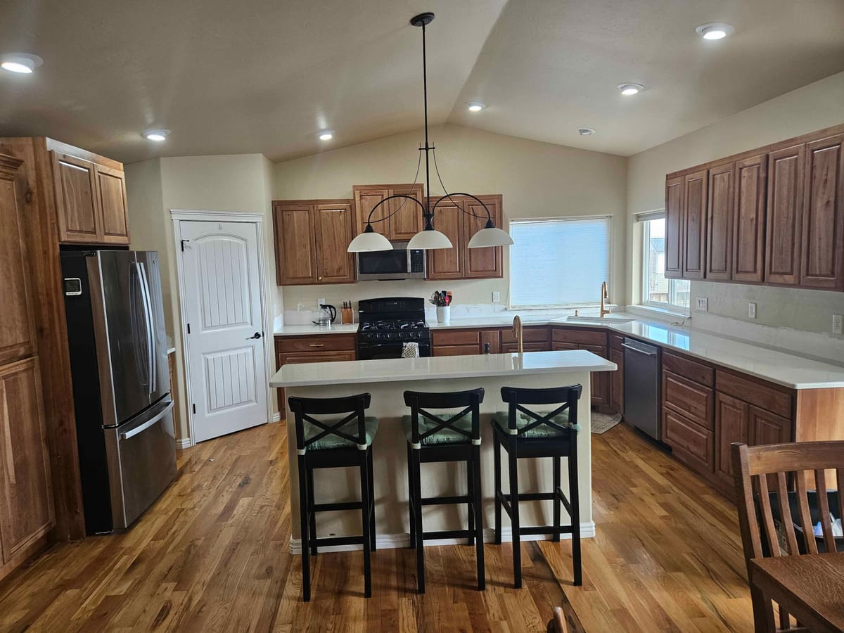 Full custom kitchen in Twin Falls with rustic alder cabinets, a white quartz island, and gold fixtures